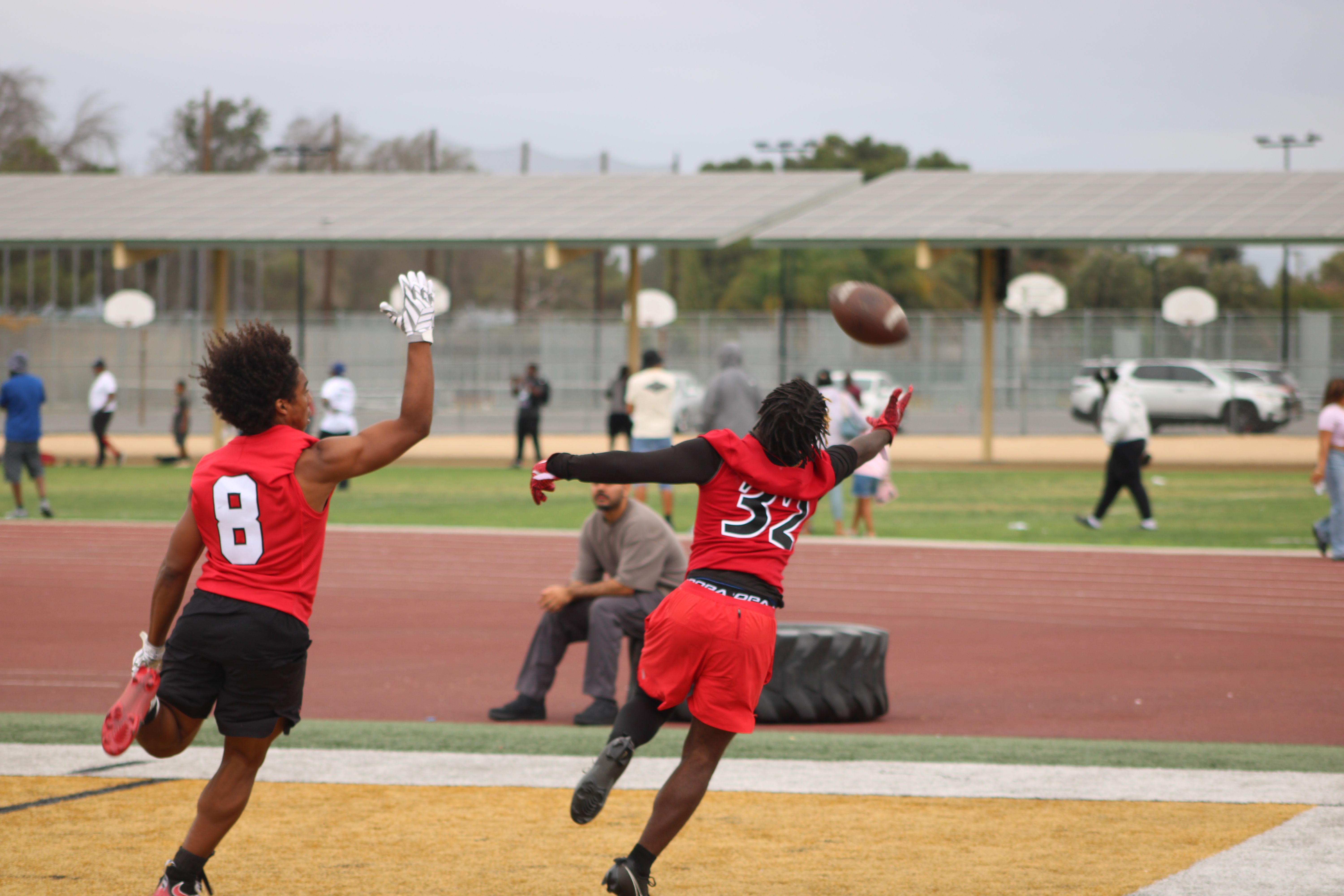 Players reaching for a pass during the high school 7v7 football event